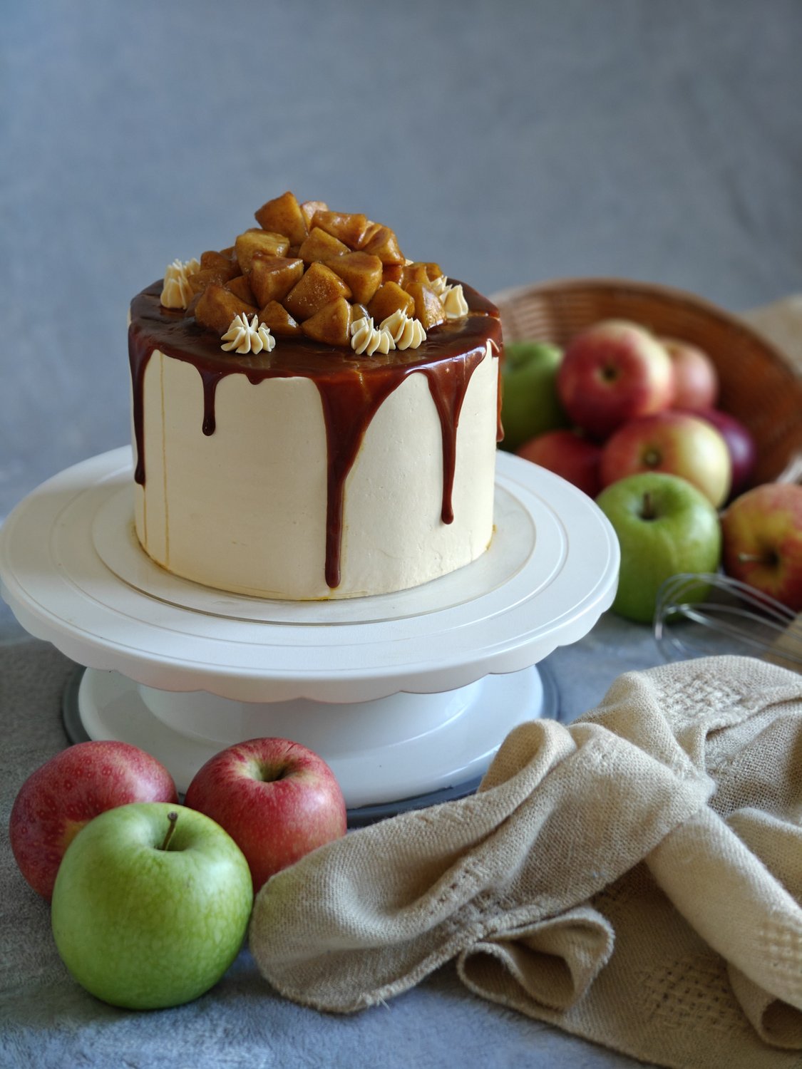 Two-tier cake with caramel drip and apple slices